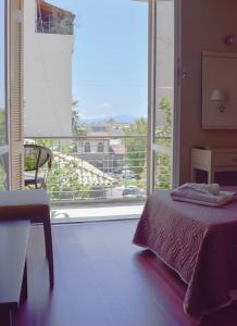 卡拉马塔City Center Hotel的一间卧室设有一张床和一个大窗户
