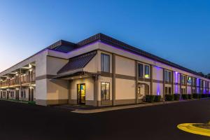 费耶特维尔Days Inn & Suites by Wyndham Fort Bragg/Cross Creek Mall的紫色照明的建筑的 ⁇ 染