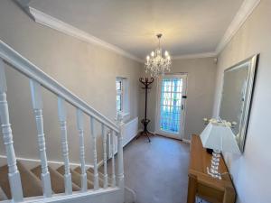 泰恩茅斯Seaview House, Tynemouth - Luxury Family Holiday Home的走廊上设有吊灯的楼梯