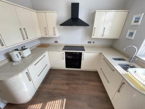 泰恩茅斯Seaview House, Tynemouth - Luxury Family Holiday Home的白色的厨房配有白色橱柜和水槽