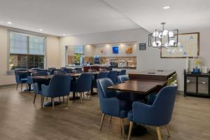 纽波特纽斯Comfort Inn Newport News - Hampton I-64的一间配备有桌子和蓝色椅子的用餐室