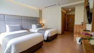莱卡邦Canalis Suvarnabhumi Airport Hotel的酒店客房设有两张床和电视。