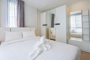 美索O2 Hotel Maesot的白色的卧室配有一张白色的大床和镜子