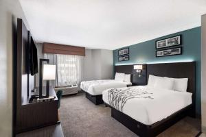 斯帕坦堡Sleep Inn的酒店客房设有两张床和一台平面电视。