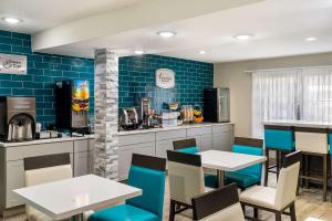 斯帕坦堡Sleep Inn的餐厅设有桌椅和蓝色瓷砖