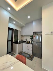 加影Homestay 3R2B Muci Residensi Zamrud, Kajang 2, Bandar Baru Bangi - non smoking homestay的厨房配有白色橱柜和不锈钢冰箱