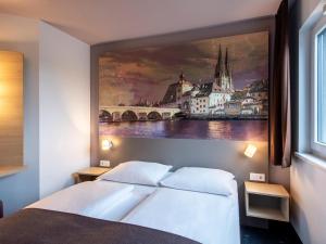 雷根斯堡雷根斯堡酒店的卧室配有一张大床上方的大画