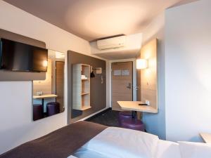 雷根斯堡雷根斯堡酒店的配有一张床和一张书桌的酒店客房