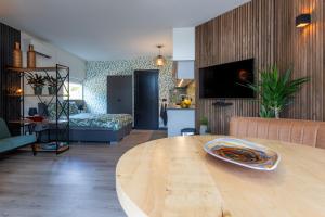 代尔登Bed & keuken De Vos的一间带木桌的客厅和一间客厅。