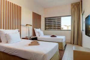 吉亚Herdade dos Salgados, Beach Villa, 3 Suites的酒店客房设有两张床和窗户。