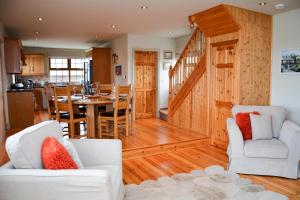 斯尼姆Beautiful stone cottage with sea views的厨房以及带木镶板的客厅。