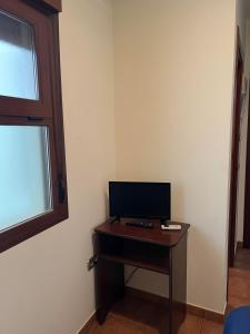 厄尔埃基多HOSTAL TREVELEZ的一间配备有书桌的客房,配备有一台电视。