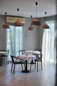 PuntaAnamar Skiathos Hotel的用餐室配有桌椅和吊灯