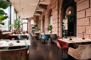 美因茨AC Hotel by Marriott Mainz的一间带桌椅的餐厅以及砖墙
