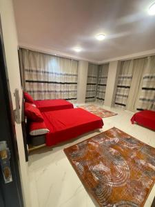 曼苏拉رويال للشقق الفندقيه的一间卧室配有红色的床和红色枕头