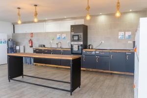 阿罗纳Ocean Nomads Coworking的一间设有蓝色橱柜和台面的大厨房