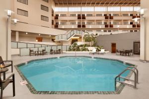圣路易斯帕克明尼阿波利斯公园双树酒店的酒店设有一个室内游泳池,配有桌椅