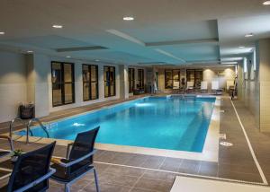福克斯伯勒Hampton Inn & Suites/Foxborough/Mansfield的酒店的大型游泳池周围设有椅子