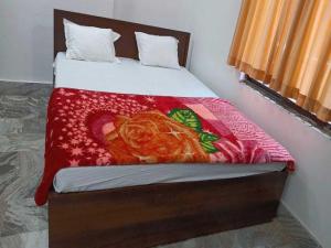 BihtaOYO Hotel K2的一间卧室配有一张床铺,床上铺有红色毯子