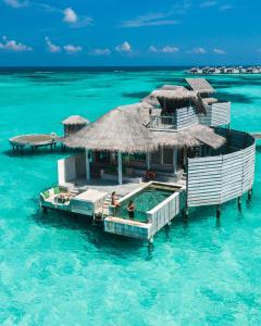 拉穆环礁拉姆岛六善酒店的海洋中的度假胜地,水中有两个人