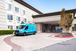 盐湖城盐湖城机场汉普顿套房酒店的停在大楼前的一辆蓝色货车