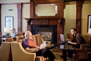 盐湖城盐湖城机场汉普顿套房酒店的一群男人坐在一个带壁炉的房间里
