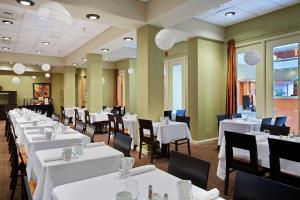 斯普林菲尔德斯普林菲尔德希尔顿逸林酒店的一间设有白色桌椅的用餐室