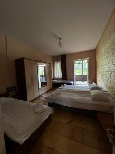 梅斯蒂亚姆斯库蒂亚娜庄园旅馆的一间卧室设有两张床和砖墙