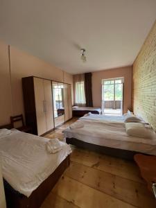 梅斯蒂亚姆斯库蒂亚娜庄园旅馆的一间卧室设有两张床和砖墙