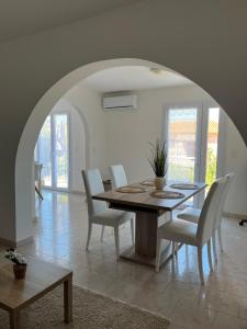 利勒鲁斯Appartement rez de villa的一间带桌子和白色椅子的用餐室