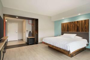 约克约克帕希尔顿Tru酒店的一间卧室配有一张带木制床头板的床