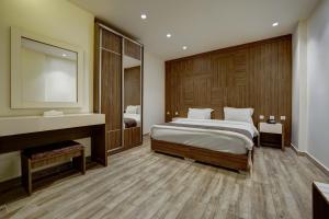 亚喀巴Luciana Hotel by BRATUS的一间卧室配有一张大床和镜子