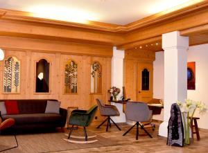 蒂罗尔州圣约翰Hotel Crystal - KitzHorn Suites的客厅配有沙发和椅子
