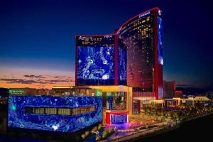 拉斯维加斯Conrad Las Vegas At Resorts World的一座大建筑,晚上有蓝色的灯光