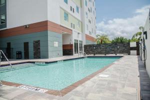 鲁兹Hilton Garden Inn Tampa Suncoast Parkway的大楼前的游泳池
