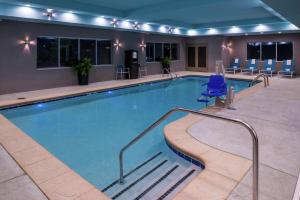 玛丽埃塔市Hampton Inn & Suites Atlanta/Marietta的酒店客房的大型游泳池配有蓝色椅子