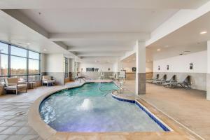 达拉斯Hilton Garden Inn Dallas-Central Expy/North Park Area, Tx的酒店大堂的大型室内游泳池,配有椅子