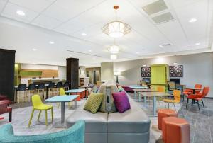 大章克申Home2 Suites By Hilton Grand Junction Northwest的一间设有桌椅和沙发的等候室