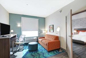 大章克申Home2 Suites By Hilton Grand Junction Northwest的酒店客房配有一张床、一张桌子和一把椅子。