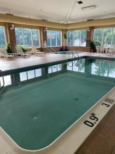 斯克兰顿Comfort Suites Scranton near Montage Mountain的大型客房的大型游泳池,配有桌椅