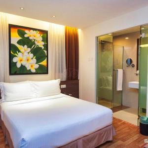 吉隆坡吉隆坡弗仁兹酒店的一间带白色大床的卧室和一间浴室