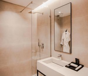 都拉斯La Onda Hotel Durres的浴室配有盥洗盆和带镜子的淋浴