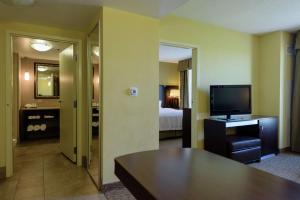 布鲁克林中心Embassy Suites by Hilton Minneapolis North的酒店客房,配有床和电视