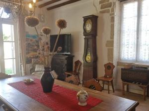 AmazyGîte du château de Chevannes的客厅配有带祖父钟的桌子