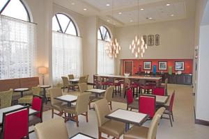 斯克内克塔迪Hampton Inn Schenectady Downtown的用餐室设有桌椅和窗户。
