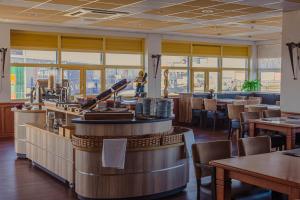 代尔夫宰尔推进器酒店的餐厅设有酒吧和桌椅