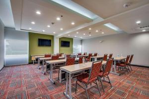 欧文Home2 Suites by Hilton DFW Airport South Irving的一间会议室,配有桌椅和屏幕
