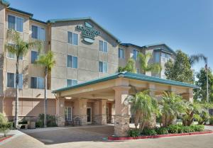 圣地亚哥圣迭戈德尔马希尔顿惠庭套房酒店的一座酒店大楼前面有棕榈树