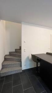 朗斯多夫Modernes Apartment的办公室,设有楼梯、书桌和楼梯间