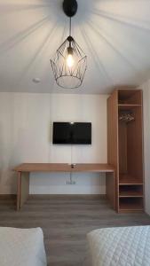 朗斯多夫Modernes Apartment的一间卧室配有一张桌子、一台电视和一盏灯
